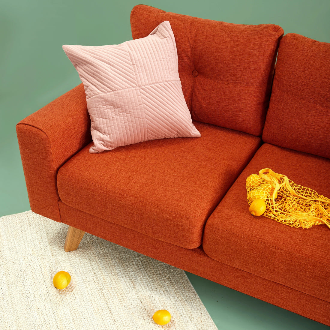 Orange sofa with a yellow net bag with lemons