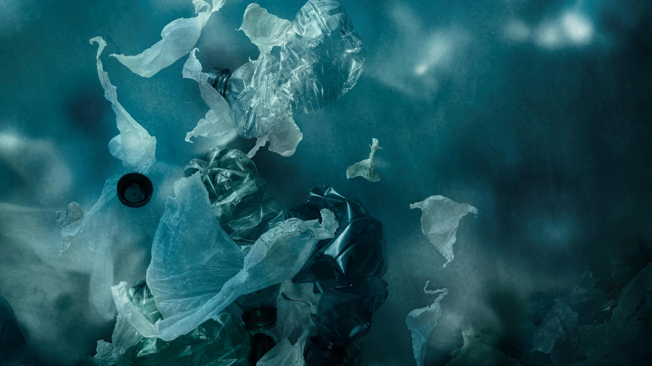 biodegradable vs compostable - plastic bottles and bags floating in the ocean 