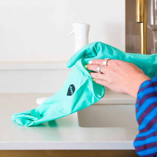 Putting on turquoise rubber gloves