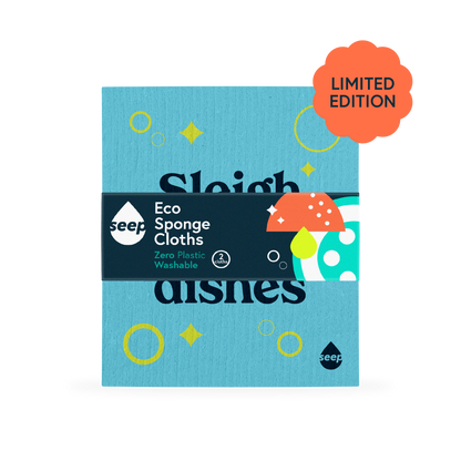 A plastic-free sponge cloth with bubbles, pings and "Sleigh the dishes" slogan printed on it, with a recyclable label around it