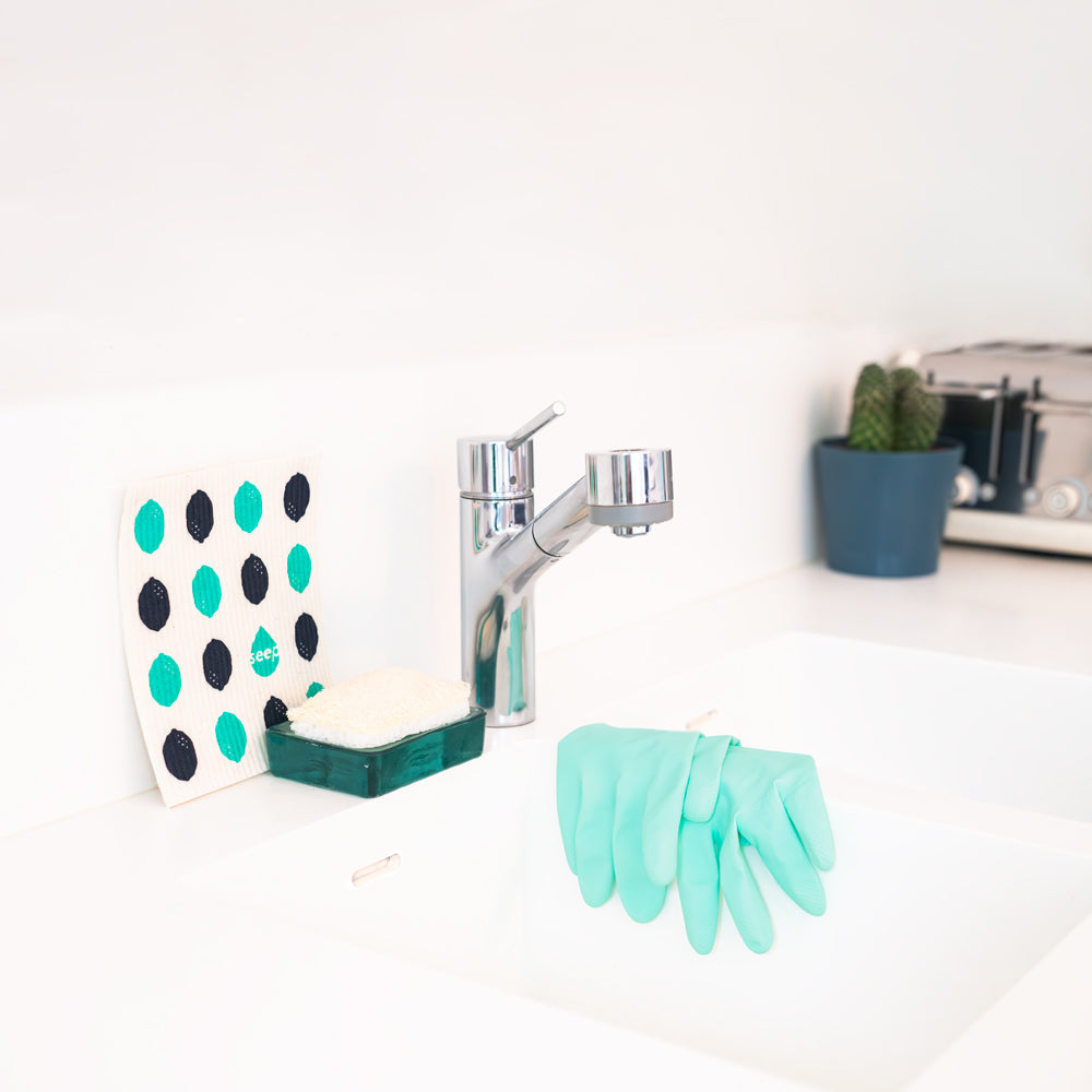 Single sponge scourer displayed on kitchen sink with sponge cloth and rubber gloves
