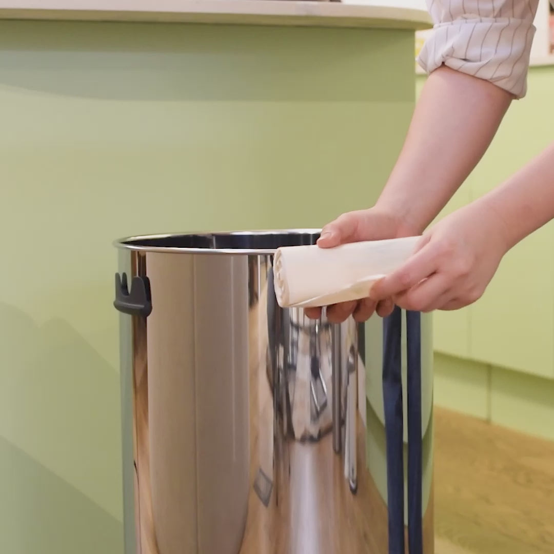 Unrolling of 50 litre biodegradable bin bag and putting it inside a kitchen bin